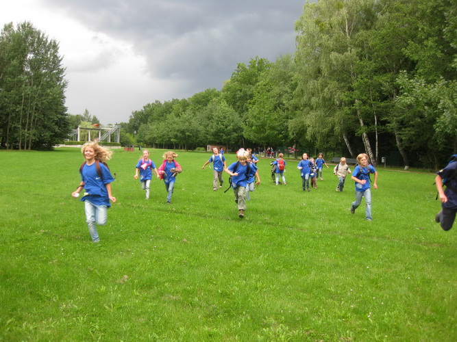 kinder laufen um wette auf wiese erlebnisferien